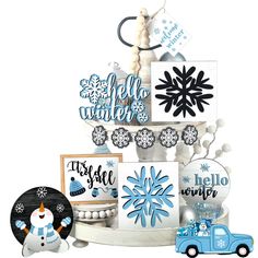 a blue truck is parked next to a tower with snowflakes and greeting cards