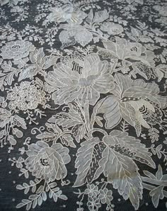 white lace on black fabric with flowers and leaves