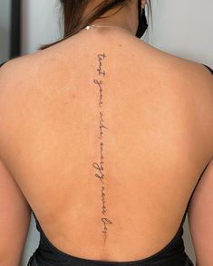 the back of a woman's neck with writing on her upper and lower back