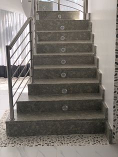 a set of stairs leading up to the second floor in a home with white walls and patterned carpet