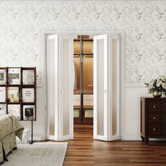 an open door leading into a bedroom with white walls and wood floors, along with a bed