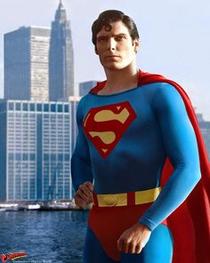 a man dressed as superman standing in front of a city