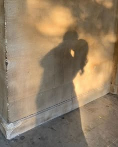 the shadow of a person standing in front of a wall