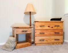 two wooden dressers sitting next to each other in a room with a lamp on top