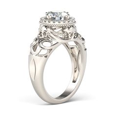 a white gold engagement ring with an oval center stone surrounded by intricate filigrees