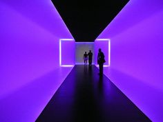 two people are walking through a purple tunnel