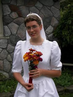 a woman in a wedding dress holding flowers