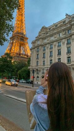 a woman is standing in front of the eiffel tower talking on her cell phone