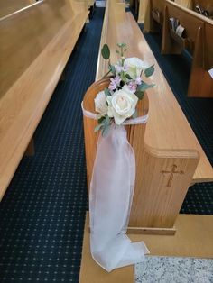 a bouquet of flowers sitting on the pews of a church