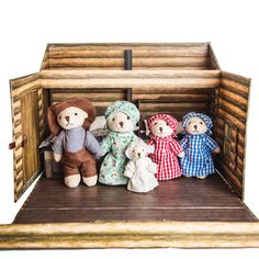 a group of teddy bears sitting inside of a wooden box