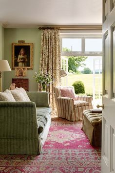 a living room filled with furniture and a pink rug