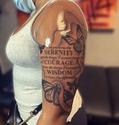 a woman with a butterfly tattoo on her arm and the words serenity, courage, and wisdom