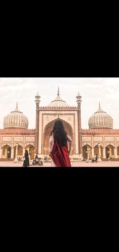 a woman standing in front of a large building