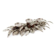 three silver candles with pine cones and leaves