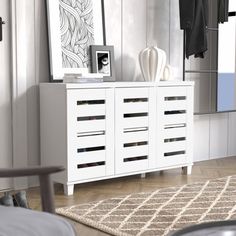 a white dresser sitting in a bedroom next to a mirror