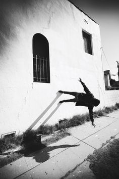 a person jumping in the air near a building