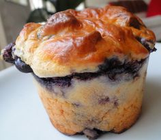 a blueberry muffin sitting on top of a white plate