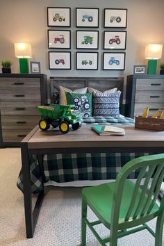 a green toy truck sitting on top of a wooden table in front of a bed