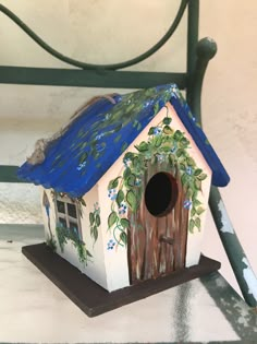 a painted birdhouse sitting on top of a table