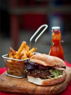 a hamburger and french fries on a cutting board