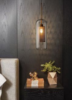 a lamp that is on top of a table next to some books and a plant