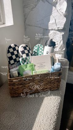 a basket filled with personal care items sitting on top of a white bed next to a window