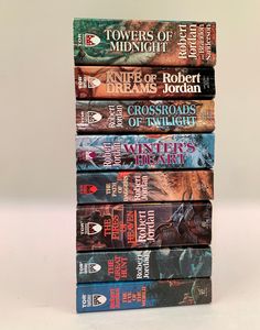 five books stacked on top of each other in front of a white background with the title tower of midnight