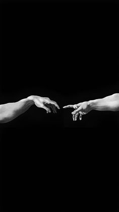 two hands reaching out towards each other in black and white, against a dark background