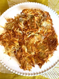 a white plate topped with fried food on top of a yellow and white table cloth