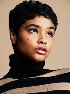 a woman with freckles on her face and black hair is looking at the camera