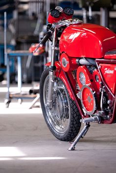 a red motorcycle parked inside of a garage