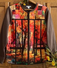 a jacket hanging on a door with flowers in front of it and an image of trees