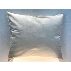 a white pillow sitting on top of a table next to a light blue painted wall