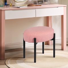 a pink stool sits in front of a white desk with a mirror and other items on it