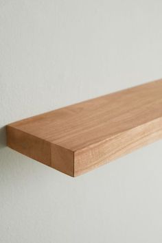 a wooden shelf mounted to the side of a wall