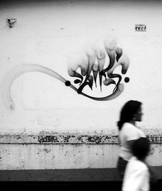 a woman walking past a graffiti covered wall