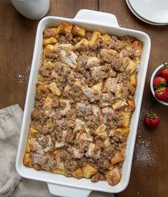 a casserole dish with some strawberries on the side