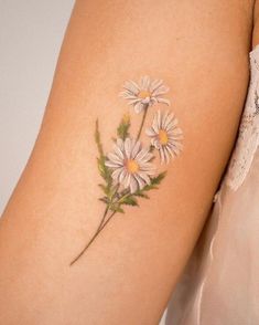 a woman's arm with daisies painted on it