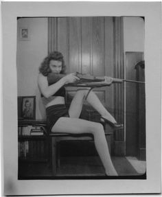 an old photo of a woman sitting on a chair with her legs crossed and stockings tied up