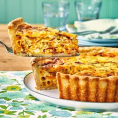 a quiche on a plate being lifted with a serving fork from the pie dish