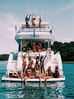 a group of people on a boat in the water with their arms up and legs out