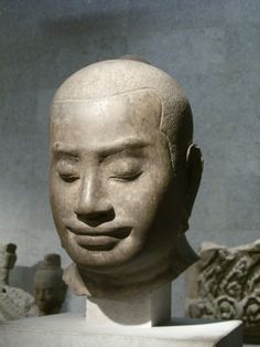 an ancient head is on display with other artifacts in the backgrouffs