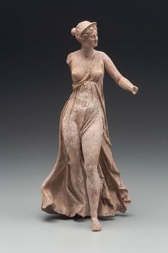 a statue of a woman wearing a dress and holding her hand out to the side