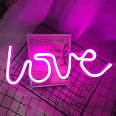 a neon sign that says love in front of a purple background with the word disconti