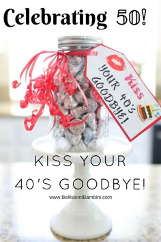 a jar filled with candy sitting on top of a table next to a sign that says celebrating 50