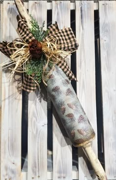 a bottle wrapped in burlock and tied with a pinecone bow sitting on top of a wooden pallet