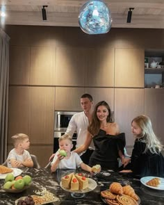 a family is gathered around the kitchen table