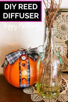 an orange pumpkin sitting on top of a table next to a glass bottle