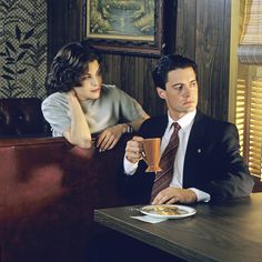 a man and woman sitting at a table in a restaurant