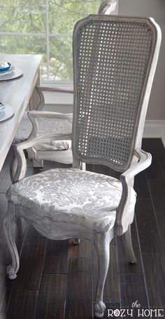 a white chair sitting in front of a window on top of a hard wood floor